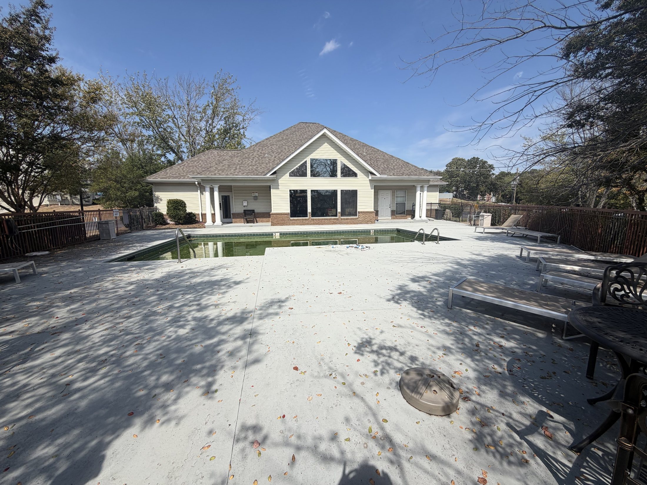 Before: the back of the clubhouse across a bare pool deck