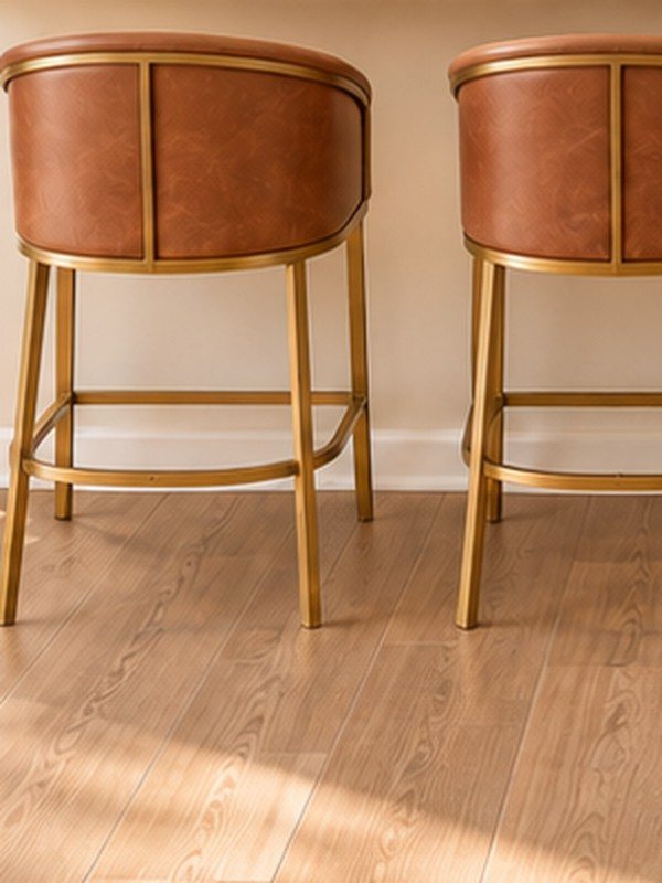 Detail: a cognac leather stool with brass frame at the quartz counter