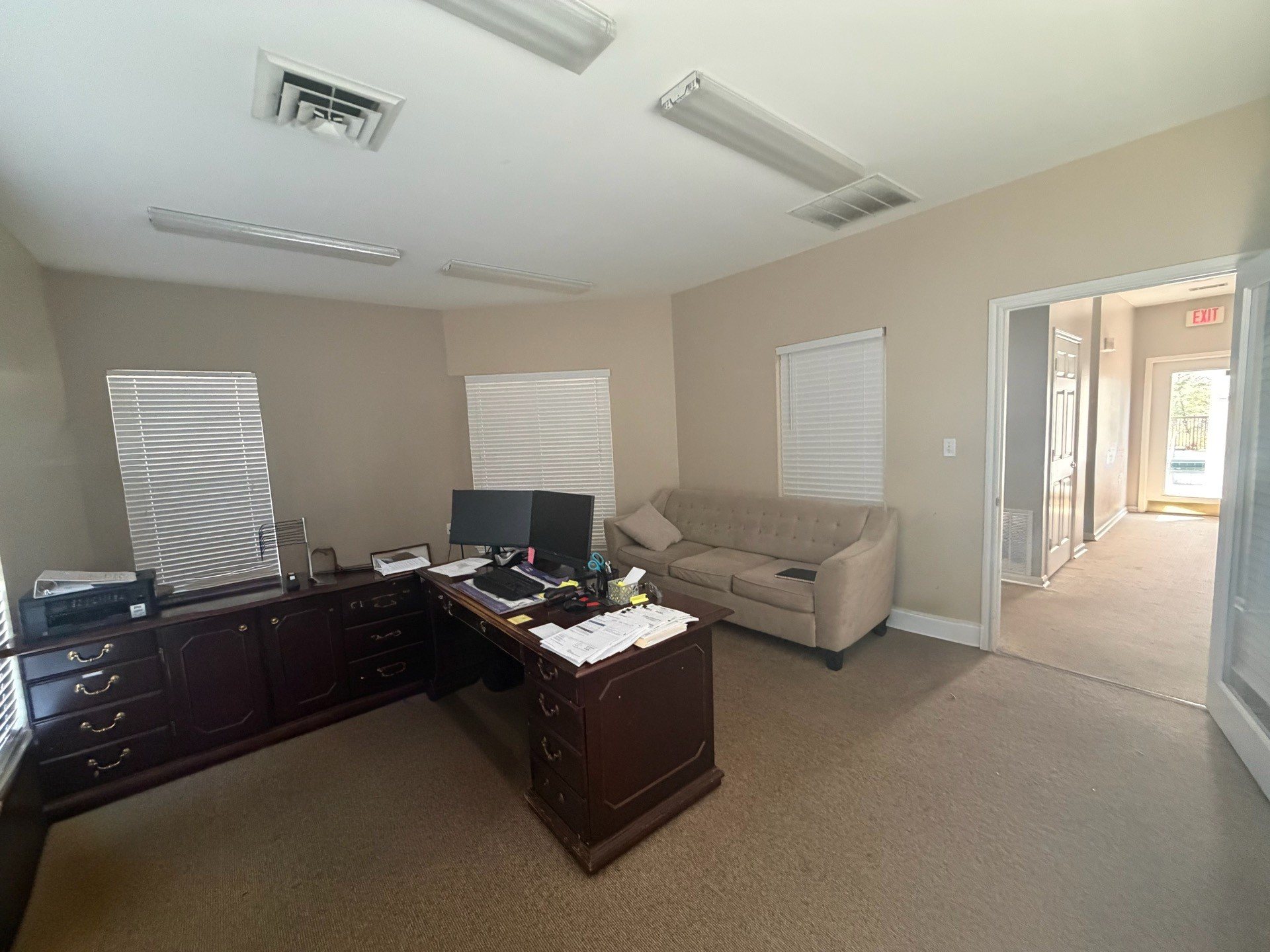 Before: the office space looking toward the hallway, with a sofa and desk