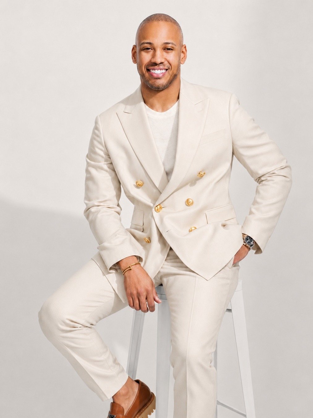 Brandon Brown, seated, in an ivory double breasted suit