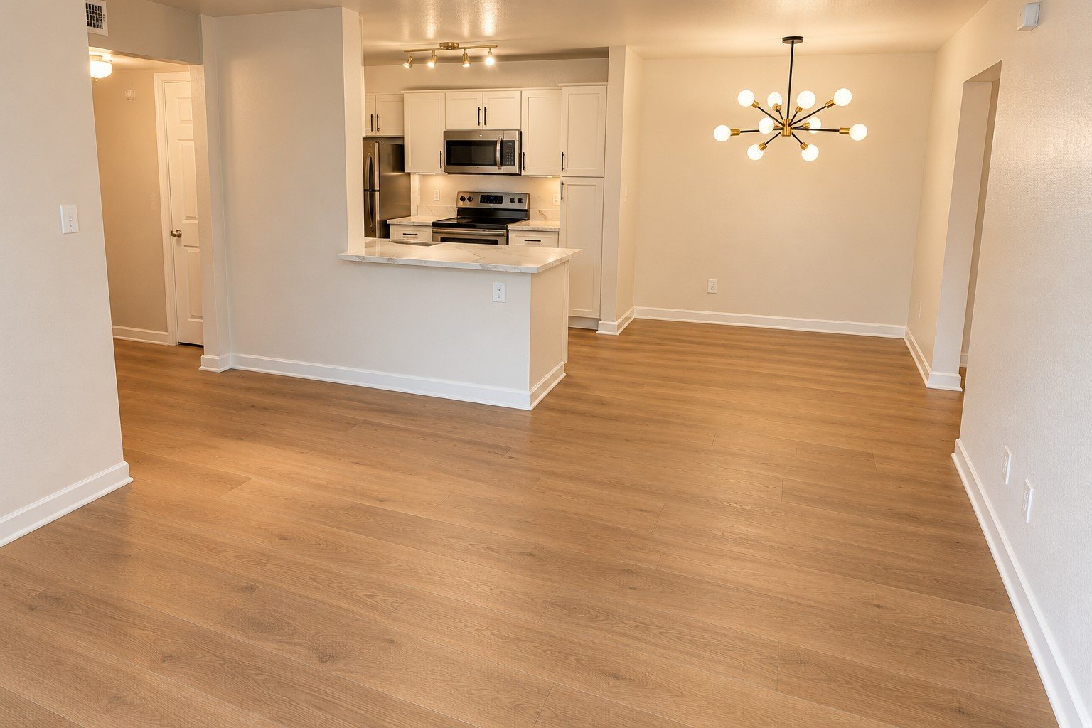 After: the living room with light oak floors, warm walls and a brass sputnik light
