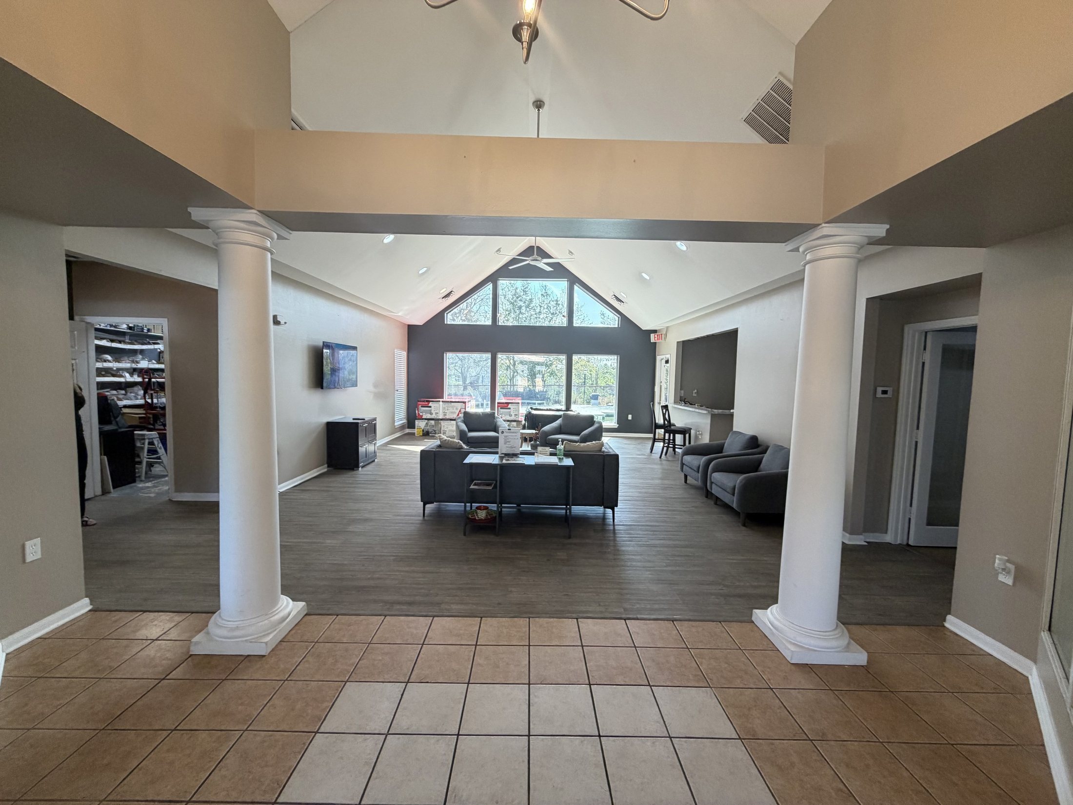 Before: the lounge looking toward the pool, with tile floor and grey seating